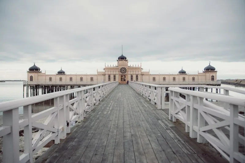 Das Kaltbadehaus von Varberg auf seinen Pfählen im Meer, ein weißer Holzsteg führt darauf zu