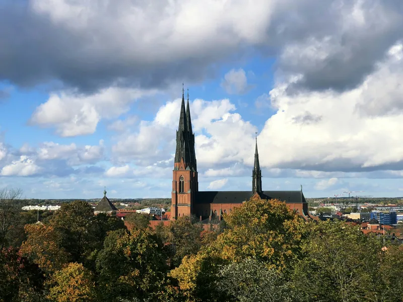 Der Dom von Uppsala über den Dächern der Stadt unter Wolkenhimmel